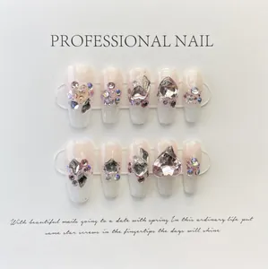 Detail of pink gradient press-on nails with 3D rhinestones and heart decorations