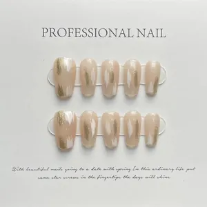 Detail of luxury press-on nails in nude pink with handmade gold and white artistic texture