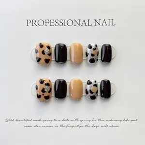 Macro detail of handmade leopard print and glitter press-on nails on display