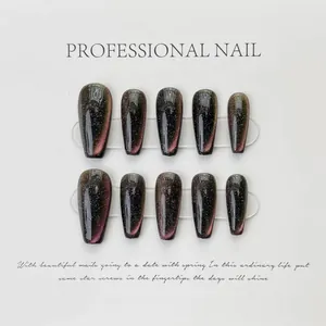 Detailed macro view of long trapezoidal press-on nails with dark cat eye effect and glitter