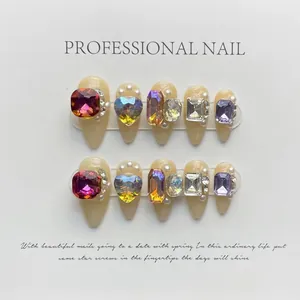 Detailed view of 10pcs luxury nude press-on nails with large iridescent gemstones and pearls