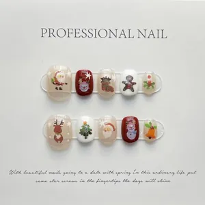 Detail view of 10 Christmas press-on nails featuring Santa and reindeer on white board