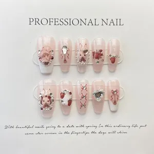Macro shot of 10-piece handmade pink press-on nails with 3D bunny and pearl charms