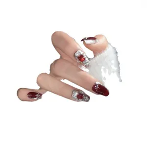 Unghie finte rosse occhio di gatto con glitter argento e gemme su sfondo bianco