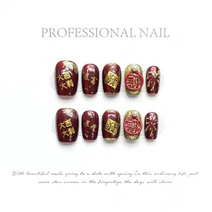 Deep red cat eye press-on nails with golden New Year characters and pearl accents
