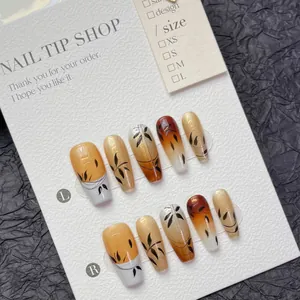 Handmade coffin press-on nails with amber gradient and black bamboo leaf floral patterns