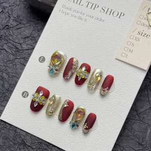 Luxury handmade press-on nails in matte wine red and champagne gold with crystals