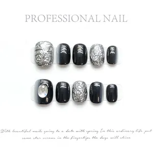 Handmade black and silver press-on nails set with 3D embossed texture and rhinestone accents