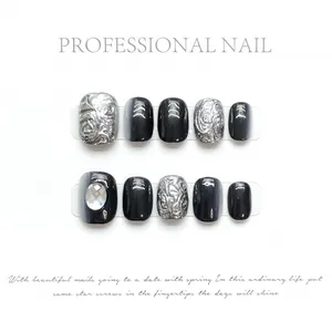 Handmade black and silver cat eye press-on nails with metallic embossed relief patterns