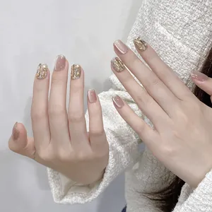 Pearlescent cat eye press-on nails with nude pink base and golden glitter accents