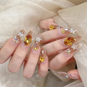 Handmade gradient nude press-on nails with amber stones, stars, and pearls on silk