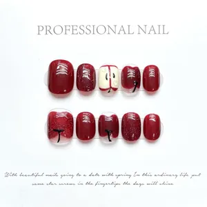Handmade red apple press-on nails featuring glitter and hand-painted fruit slice designs