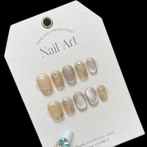 Handmade cat eye press-on nails with 3D gold flowers and rhinestones on display card