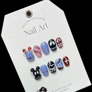 Faux ongles faits main avec motifs d'Halloween comprenant globes oculaires et crânes