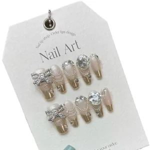 Handmade press-on nails with luxury 3D bow, rhinestones, and French gold chrome tips
