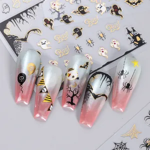 Stickers nail art Halloween avec fantômes et araignées dorés sur des ongles dégradés