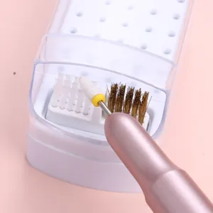 Reinigingsset voor nagelbitjes met opbergdoos en tweekoppige borstel op roze ondergrond