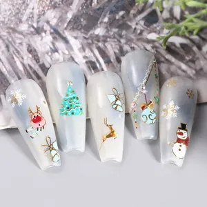 Macro detail of Christmas nail stickers with gold foil reindeer and snowflake designs