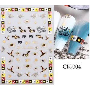 Gros plan de stickers à ongles Halloween avec toiles d'araignées dorées et motifs effrayants