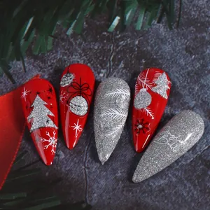 Macro view of Christmas stiletto press-on nails with silver glitter and snowflake patterns