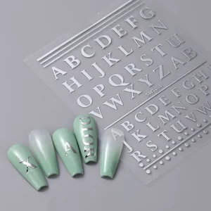 Détail macro de stickers alphabétiques argentés sur ongles avec dégradé vert