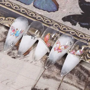 Détail macro de stickers ongles papillon aurore avec strass et accents de chaîne argentée
