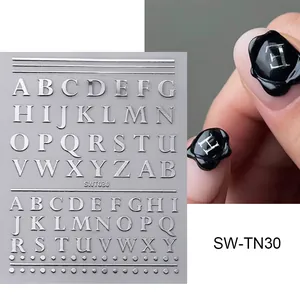 Gros plan sur des autocollants à ongles lettres argentées et effet de manucure 3D laqué