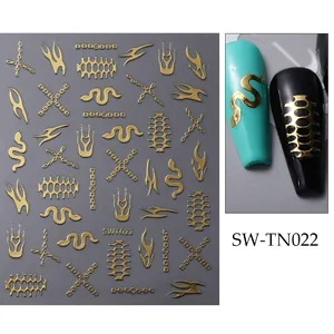 Détails macro de stickers d'ongles dorés avec motifs de flammes et chaînes sur ongles noirs