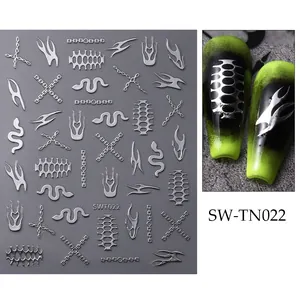 Détail d'autocollants punk argentés pour ongles avec motifs de flammes et de serpents