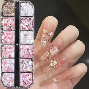 Detail of 12-grid nail art set with pink hearts, stars, and 3D bow rhinestone decorations