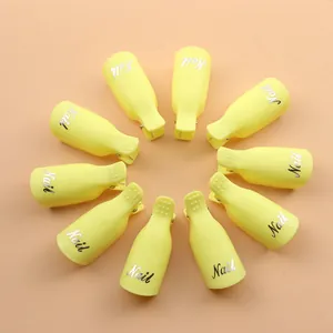 Detalle de diez pinzas amarillas para uñas para quitar el esmalte de gel en un círculo