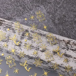 Nahaufnahme goldener 3D-Weihnachts-Nagelaufkleber mit Lebkuchen- und Rentier-Motiven