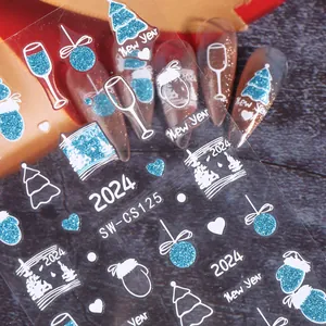 Detail of blue glitter Christmas nail stickers with 2024 New Year tree and snowflake motifs