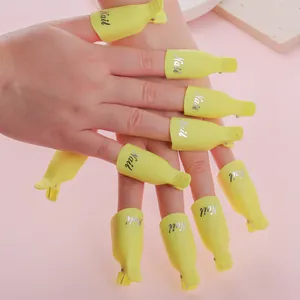 Pack de 10 pinzas amarillas para quitar esmalte de uñas sobre fondo rosa suave
