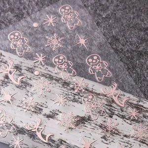 Nahaufnahme von 3D-Weihnachts-Nagelaufklebern in Roségold mit Rentier- und Schneeflocken