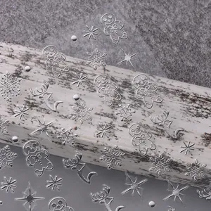 Detailaufnahme von 3D-Weihnachtsnagelstickern in Silber mit Schneeflocken und Lebkuchenmann