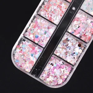 Macro detail of pink heart and star shaped nail art sequins in a clear organizer box