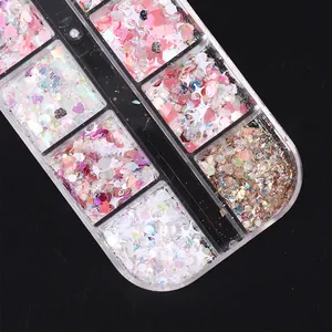 Macro detail of mixed pink heart and star nail sequins in a multi-grid storage box