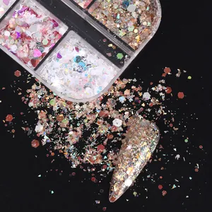 Close-up of pink heart and star nail sequins in a multi-grid storage case with sample nail