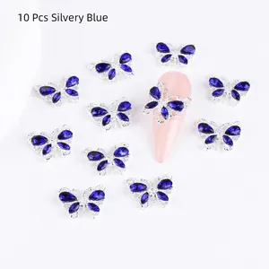 Detailed close-up of 10 silvery blue butterfly nail charms with rhinestones on nails
