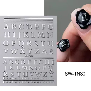 Makroaufnahme von silbernen 3D-Alphabet-Nagelstickern mit metallischem Relief-Effekt