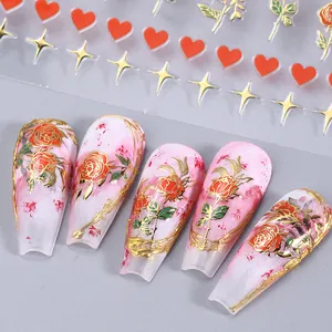 Detail of 3D nail stickers featuring red roses, gold stars and hearts on manicure tips
