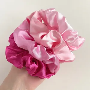 Three-piece satin scrunchie set in shades of pink, soft texture and smooth fabric detail
