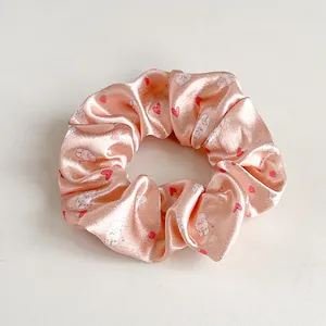 Dettaglio dell'elastico in raso rosa con stampe di conigli, cuori e fragole