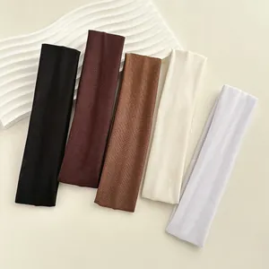 Dettaglio di cinque fasce per capelli elastiche colorate in maglia a coste minimalista