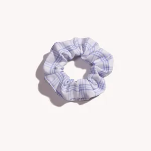 Dettaglio scrunchie a quadretti blu e bianchi con morbido tessuto a pieghe ed elastico