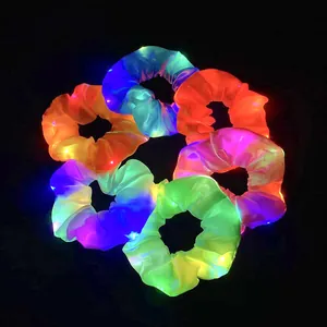 Leuchtende LED-Haargummis aus Satin in bunten Farben auf einem dunklen Hintergrund
