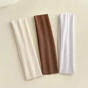 Primo piano di tre fasce in maglia elastica nei colori beige, marrone e bianco a costine
