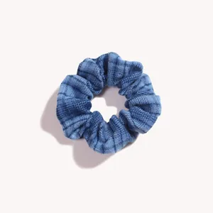Dettaglio dell'elastico per capelli scozzese blu in denim con design a pieghe