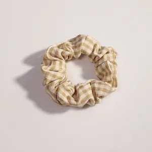Dettaglio del motivo a quadretti kaki e della morbida trama in cotone dello scrunchie